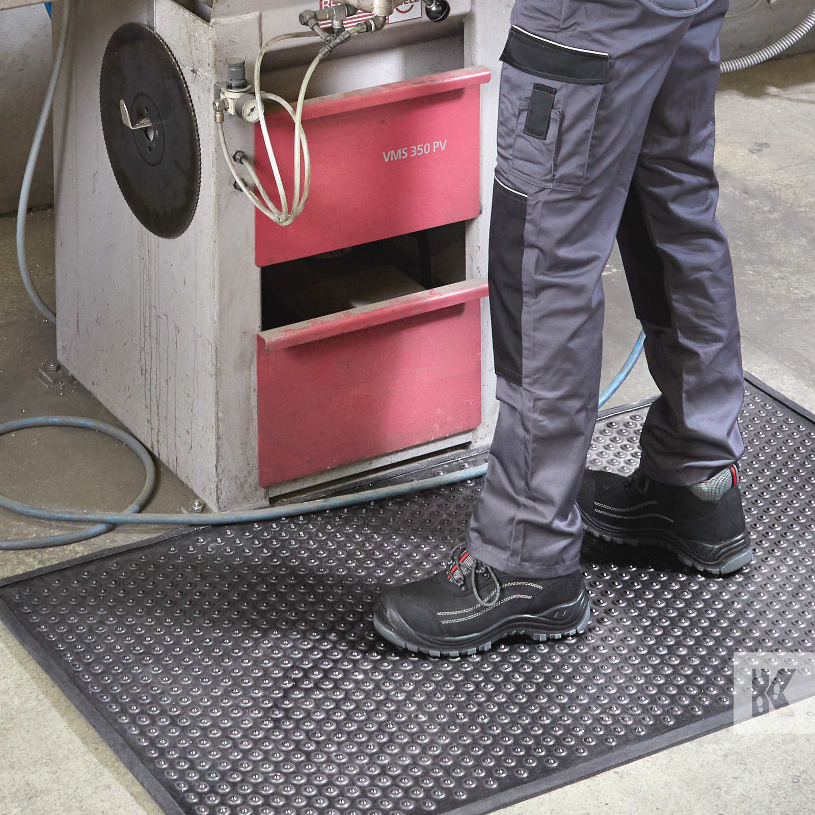 Kleen-Coil - Close up of a man in workpants while standing on an anti-fatigue mat