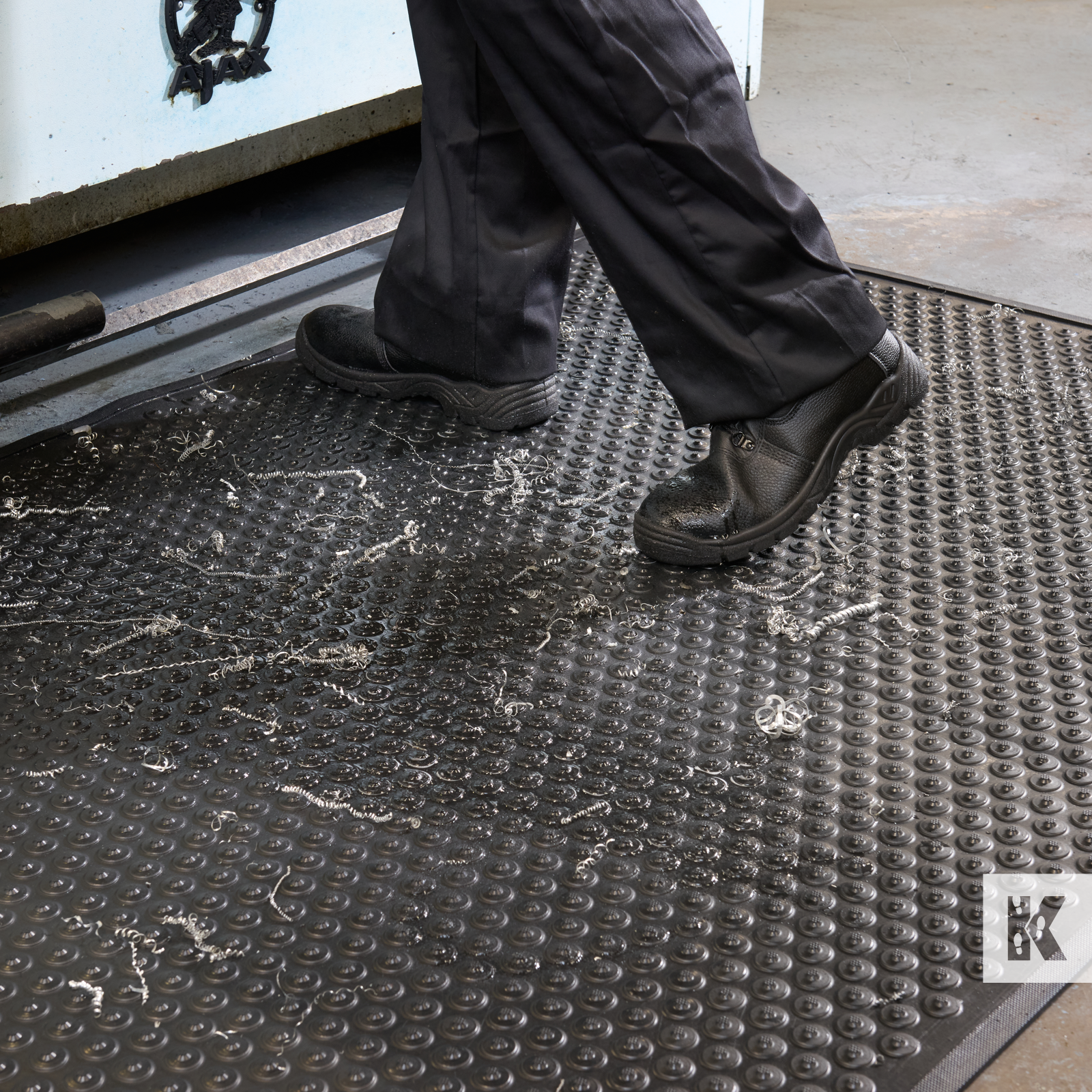 Kleen-Coil - Close up of a man working while standing on an anti-fatigue mat