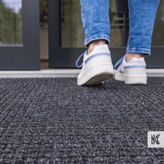 Water-Horse - Close up of legs in denim and white training shoes walking on a mat with a 3d textured surface