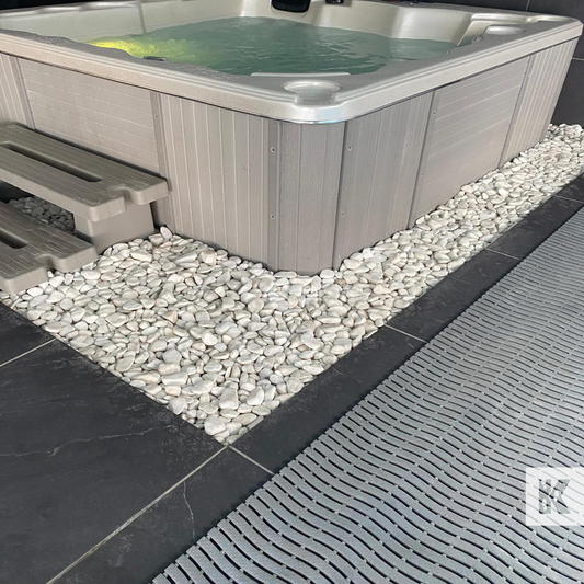 Modular floor tile next to Jacuzzi sat on white stones